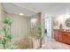 Bathroom featuring a glass shower, tile floors, and brown cabinets with granite countertops at 736 Island Way # 303, Clearwater Beach, FL 33767