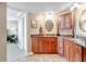 Bathroom featuring brown cabinetry with granite countertops, tile floors, and a vanity at 736 Island Way # 303, Clearwater Beach, FL 33767