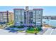 A full exterior shot of a large condo building surrounded by manicured lawns and mature palm trees at 736 Island Way # 303, Clearwater Beach, FL 33767