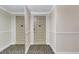 Hallway shot showing doors 302 and 303 with neutral walls, patterned carpeting and white trim at 736 Island Way # 303, Clearwater Beach, FL 33767