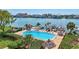 Community pool overlooking the water, complete with lounge chairs, docks and tiki hut at 736 Island Way # 303, Clearwater Beach, FL 33767