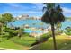Inviting waterfront community pool with tiki huts, lounge chairs and lush tropical landscaping overlooking the bay at 736 Island Way # 303, Clearwater Beach, FL 33767