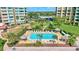 Aerial view of community pool and lounge area with manicured landscaping and multiple seating options at 736 Island Way # 303, Clearwater Beach, FL 33767