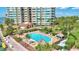 Community pool with lounge chairs is surrounded by tropical landscaping and has shaded seating areas at 736 Island Way # 303, Clearwater Beach, FL 33767