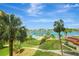 Beautiful view of the water, pool, palm trees, lush landscaping and boat docks from the property at 736 Island Way # 303, Clearwater Beach, FL 33767