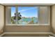 Bright room features a large window with a beautiful view of the waterfront, pool and palm trees at 736 Island Way # 303, Clearwater Beach, FL 33767