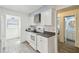 Bright kitchen featuring modern appliances, white cabinets, and a view into the adjacent bathroom and laundry area at 7822 Radcliffe Cir, Port Richey, FL 34668