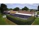 Aerial view of houses featuring backyard pools and fences surrounded by green lawns at 7944 Royal Hart Dr, New Port Richey, FL 34653
