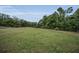 Picture of vacant lot with trees in the background and overhead power lines at 7944 Royal Hart Dr, New Port Richey, FL 34653