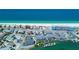 Breathtaking aerial view of beachfront homes and waterfront with boats docked in a calm bay at 9921 Gulf Blvd, Treasure Island, FL 33706