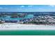 Stunning aerial view of beachfront property with white sand, emerald water, and cityscape backdrop at 9921 Gulf Blvd, Treasure Island, FL 33706