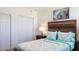 Bright bedroom featuring a wooden headboard, patterned bedding, and closet with double doors at 9921 Gulf Blvd, Treasure Island, FL 33706