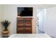 Bedroom featuring a wooden dresser with a TV, an indoor plant and view to open closet at 9921 Gulf Blvd, Treasure Island, FL 33706