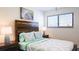 Cozy bedroom with a rustic wooden headboard, matching nightstands, and a window with blinds at 9921 Gulf Blvd, Treasure Island, FL 33706