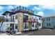 Charming building exterior with stone accents, balconies, rooftop deck, and well-maintained landscaping at 9921 Gulf Blvd, Treasure Island, FL 33706