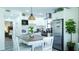 Well-equipped kitchen with modern appliances, white cabinets, and open layout to dining area at 9921 Gulf Blvd, Treasure Island, FL 33706