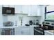 Contemporary kitchen with stainless steel appliances, white cabinets, and stylish fixtures at 9921 Gulf Blvd, Treasure Island, FL 33706