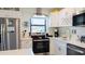 Modern kitchen with stainless steel appliances, white cabinets, and quartz countertops at 9921 Gulf Blvd, Treasure Island, FL 33706