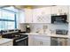Bright kitchen featuring stainless steel appliances, white cabinets, and quartz countertops at 9921 Gulf Blvd, Treasure Island, FL 33706