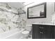 Modern bathroom with marble tiled shower, modern vanity, and large mirror at 12110 75Th St, Largo, FL 33773
