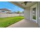 View of the green backyard and patio area with a ceiling fan with a white fence at 12280 Lyon Pine Ln, Odessa, FL 33556