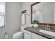 Well-lit bathroom features a granite countertop, wooden framed mirror, and modern fixtures at 12280 Lyon Pine Ln, Odessa, FL 33556