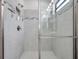Shower with tiled walls, a shower head, and glass doors at 12280 Lyon Pine Ln, Odessa, FL 33556