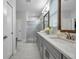 Bathroom with dual sinks, grey cabinets, granite countertops, and a glass shower at 12280 Lyon Pine Ln, Odessa, FL 33556