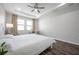 Bright bedroom featuring wood-look flooring, a ceiling fan, and a large window at 12280 Lyon Pine Ln, Odessa, FL 33556