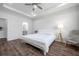 Bright bedroom with wood-look flooring, a ceiling fan, and a chair at 12280 Lyon Pine Ln, Odessa, FL 33556