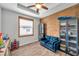 Bedroom with wood accent wall, ceiling fan, and wood-look floors at 12280 Lyon Pine Ln, Odessa, FL 33556