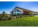 Modern clubhouse with large windows and a manicured lawn, offering a welcoming space for community events and gatherings at 12280 Lyon Pine Ln, Odessa, FL 33556