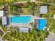 Aerial view of community amenities featuring a pool, splashpad, lounge chairs, and manicured grounds for relaxation at 12280 Lyon Pine Ln, Odessa, FL 33556