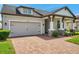 The house featuring a paver driveway and manicured landscaping at 12280 Lyon Pine Ln, Odessa, FL 33556