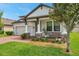 Charming home featuring a covered porch with stone accents and a well-manicured lawn at 12280 Lyon Pine Ln, Odessa, FL 33556