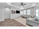 Bright living room features modern ceiling fan, recessed lighting, and neutral color palette with floating shelves at 12280 Lyon Pine Ln, Odessa, FL 33556