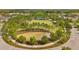 Aerial shot of a green park with surrounding trees, walking paths, and play area at 12280 Lyon Pine Ln, Odessa, FL 33556