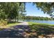 Scenic paved walking path by the lake surrounded by mature trees and lush landscaping in a peaceful setting at 12280 Lyon Pine Ln, Odessa, FL 33556