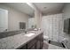Bright bathroom with a large vanity, granite countertop and patterned shower curtain at 13227 Great Plains Dr, Riverview, FL 33579