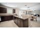 Open kitchen featuring a granite island with seating, seamlessly connected to the adjacent living and dining areas at 13227 Great Plains Dr, Riverview, FL 33579