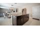 Open-concept kitchen with dark cabinets, granite countertops, a center island, and a seamless transition to the dining area at 13227 Great Plains Dr, Riverview, FL 33579