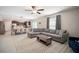 Open-concept living room featuring tile flooring, ceiling fan, and seamless flow into the dining area and kitchen at 13227 Great Plains Dr, Riverview, FL 33579