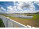Scenic view of a community pond with a white fence in the foreground at 13227 Great Plains Dr, Riverview, FL 33579