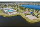 Aerial view showcasing community amenities including a pool, playground, and a scenic amphitheater by the lake at 13511 Fladgate Mark Dr, Riverview, FL 33579