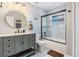 Updated bathroom with a marble vanity, modern lighting, and a glass-enclosed shower with a decorative shower curtain at 13511 Fladgate Mark Dr, Riverview, FL 33579
