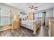 Bright bedroom with a ceiling fan, large windows, and light wood furniture on dark wood flooring at 13511 Fladgate Mark Dr, Riverview, FL 33579