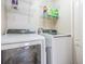 Modern laundry room with white washer, dryer, and storage shelves at 13511 Fladgate Mark Dr, Riverview, FL 33579