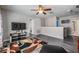 Open loft area with wood-look floors, a ceiling fan, a TV, and a colorful area rug at 13511 Fladgate Mark Dr, Riverview, FL 33579