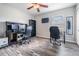 Office featuring two desks, rolling chairs, dark wood-look flooring, and a TV mounted on the wall at 13511 Fladgate Mark Dr, Riverview, FL 33579