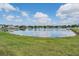 Scenic view of a tranquil pond surrounded by lush green grass and charming homes at 13511 Fladgate Mark Dr, Riverview, FL 33579
